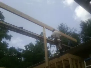 Carpenter setting a ridge beam over a new addition frame — Ice Dam Removal by Roofing Brothers in Clyde Park