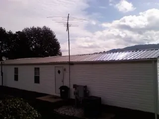 New metal roof on a single wide mobile home with a TV antenna in Clyde Park