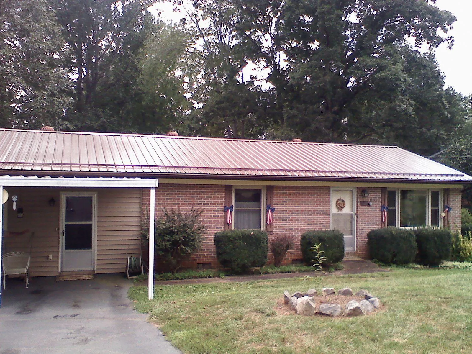 Bronze metal roof and carport on a brick ranch home — Roof Repair work by our crew in Clyde Park